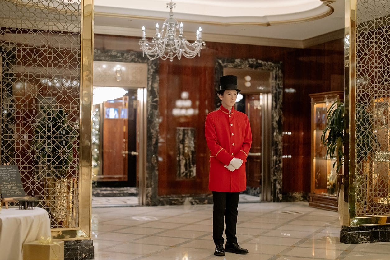 A man in red jacket standing inside of building.